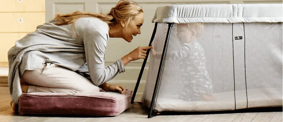 Maman avec son bébé dans un lit parapluie
