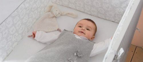 Bébé dans son lit avec une gigoteuse